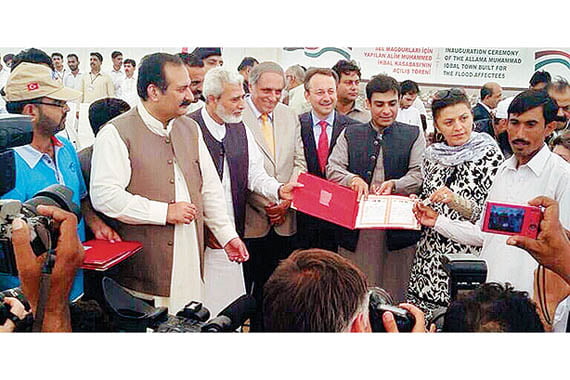 Turkish charity Kimse Yok Mu Director İsmail Cingöz and a board member present Pakistani officials with a land deed to the İkbaliye village. (Photo: Today's Zaman)