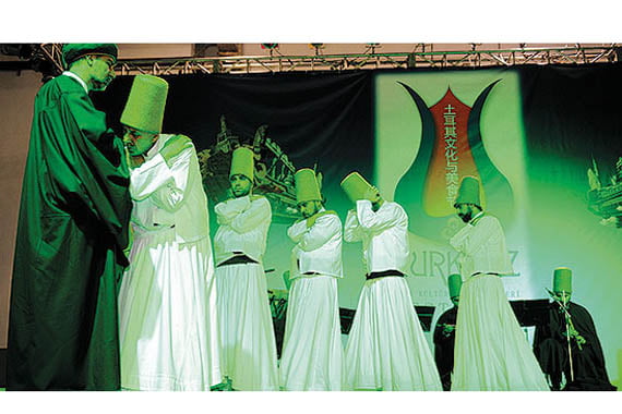 Chinese and Turkish attendees of the Turquoise Turkish Culture and Food Festival in Shanghai watched whirling dervishes performed on stage. (Photo: Hüseyin Aydın, Cihan)