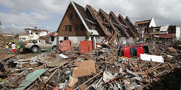 Survivors stand outside their damaged house at typhoon-hit Tacloban city, Leyte province central Philippines on Monday. (Photo: AP)