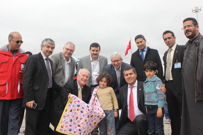 Former Purcellville mayor Robert W. Lazaro and Loudoun Board of Supervisors Chairman Scott K. York (center background, both in glasses) at a refugee camp in Turkey, handing out blankets collected last fall. (Courtesy of Northern Virginia Regional Commission)