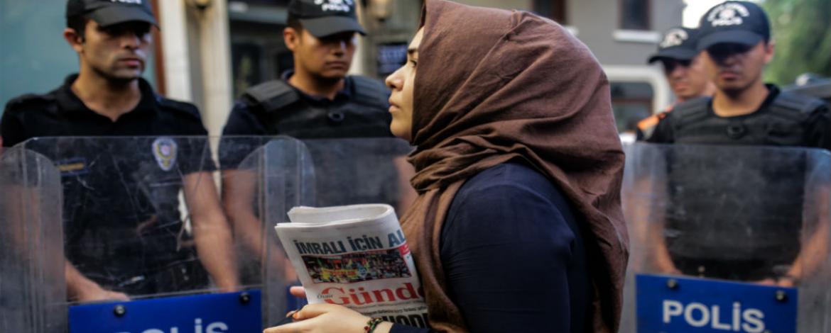 A woman holding the Ozgur Gundem newspaper, one of the outlets ordered to close by a Turkish court. Photograph: Yasin Akgul/AFP/Getty Images
