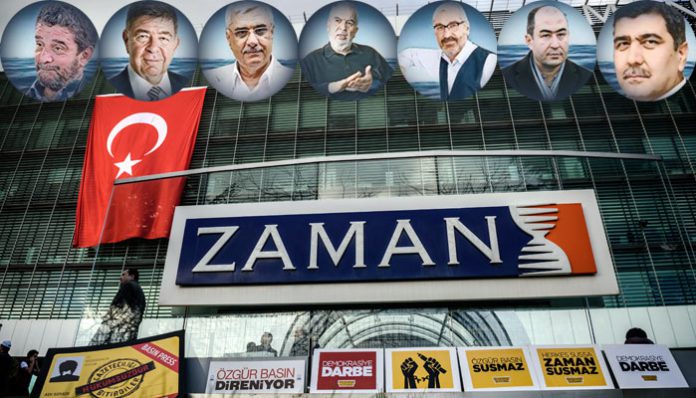 The logo of Turkish daily newspaper Zaman is seen on the headquarters building as people demonstrate in support of the newspaper in Istanbul on March 4, 2016. An Istanbul court on Friday ordered into administration the Turkish daily newspaper Zaman that is sharply critical of President Recep Tayyip Erdogan, amid growing alarm over freedom of expression in the country.